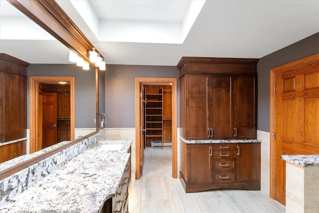 bathroom featuring a raised ceiling, vanity, and baseboard heating