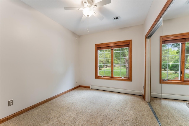 empty room with ceiling fan, carpet floors, and baseboard heating