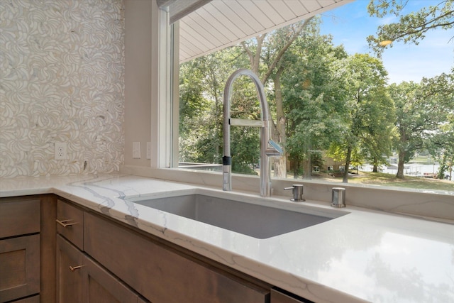 kitchen featuring sink and light stone countertops