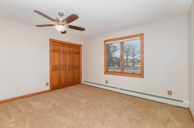 unfurnished bedroom featuring baseboard heating, ceiling fan, carpet floors, and a closet