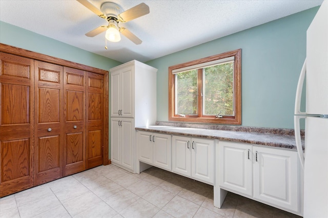 bathroom with ceiling fan and a textured ceiling