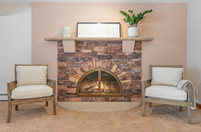 sitting room featuring a fireplace, baseboard heating, and carpet