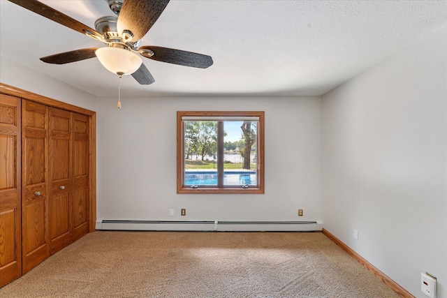 unfurnished bedroom featuring a baseboard radiator, light colored carpet, ceiling fan, a textured ceiling, and a closet