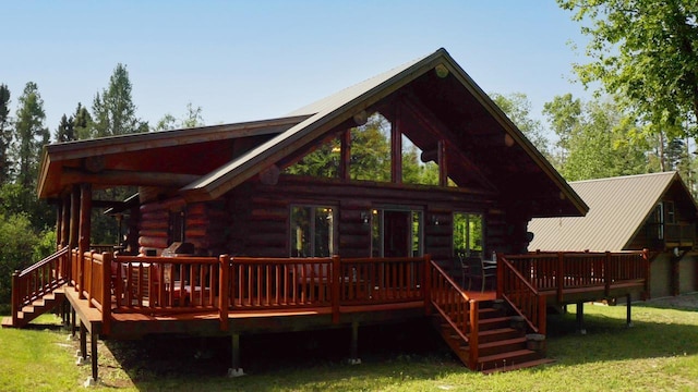 back of property with a wooden deck and a yard