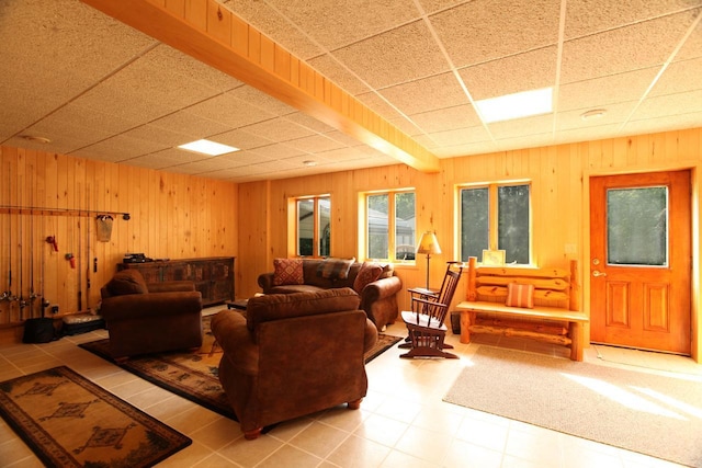 tiled living room with a drop ceiling and wood walls