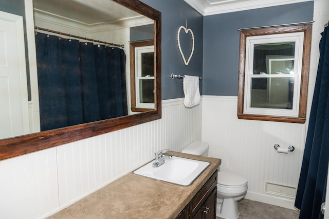 bathroom with ornamental molding, vanity, and toilet