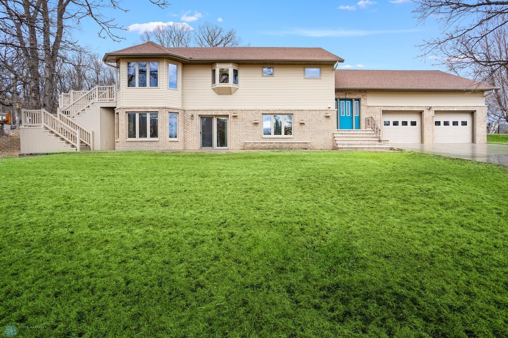 back of property featuring a yard and a garage