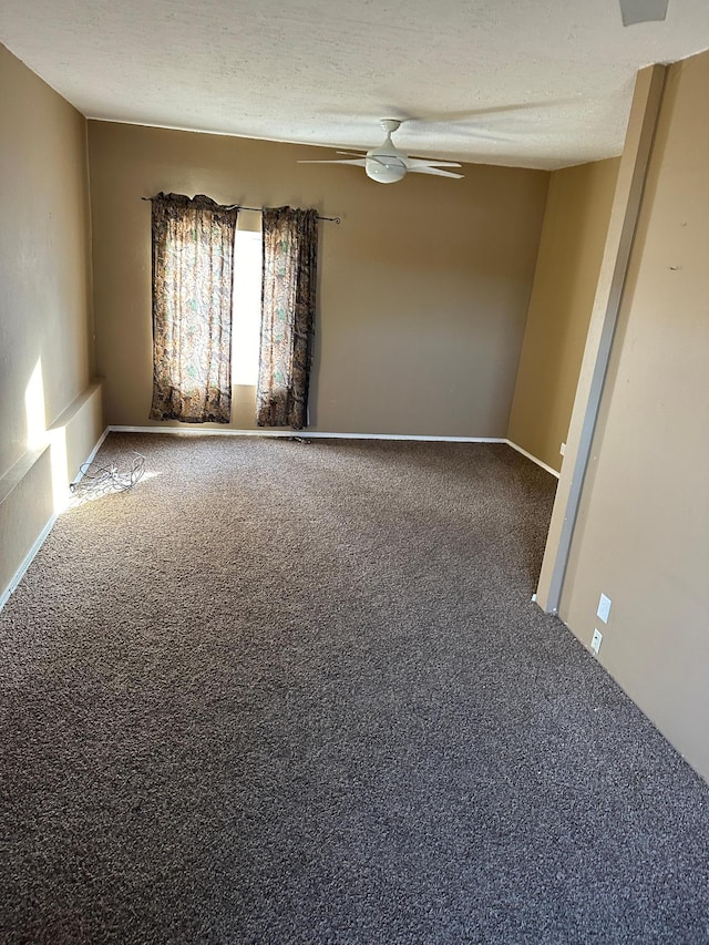 carpeted spare room featuring a textured ceiling and ceiling fan