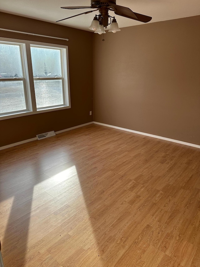 spare room with ceiling fan and light wood-type flooring