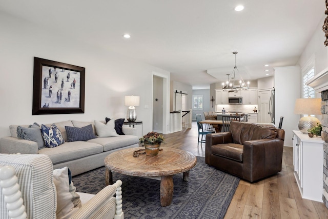 living room featuring light wood-type flooring and an inviting chandelier