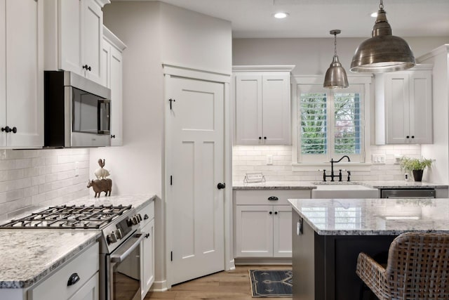 kitchen with appliances with stainless steel finishes, backsplash, and light hardwood / wood-style floors