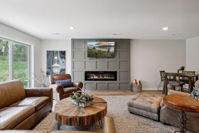 living room with a textured ceiling and light hardwood / wood-style floors