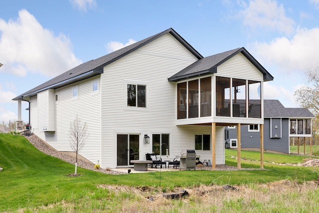 back of property featuring a yard, a patio, and a sunroom