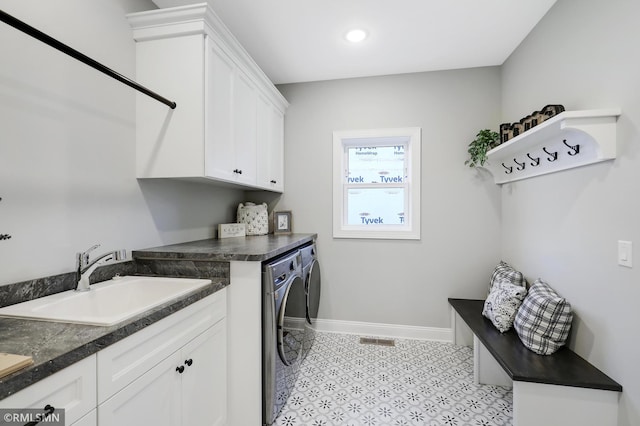 laundry area with cabinets, sink, and washing machine and clothes dryer