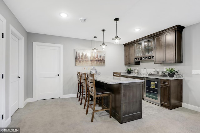 bar featuring wine cooler, dark brown cabinetry, and light colored carpet