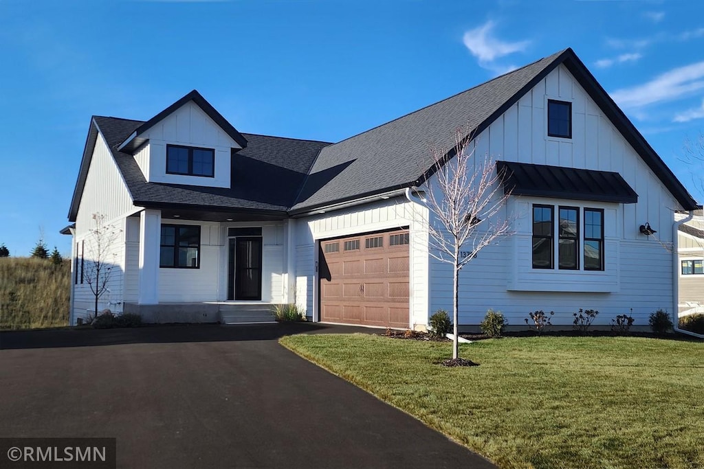 modern farmhouse style home featuring a front lawn and a garage