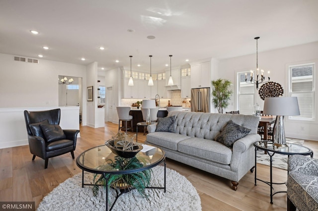 living room featuring light hardwood / wood-style flooring and a notable chandelier