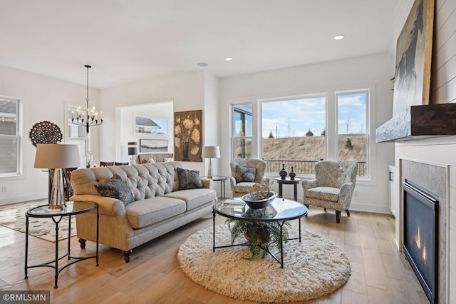 living room featuring a chandelier and light wood-type flooring