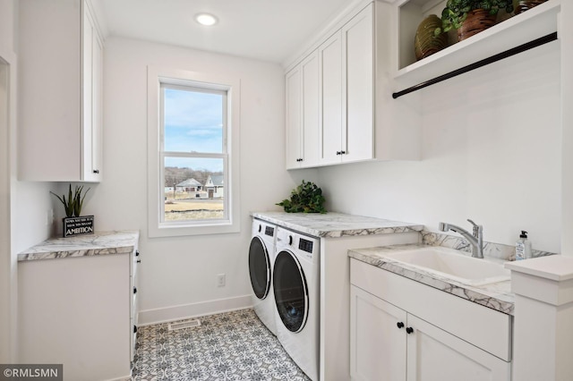 laundry area with cabinets, sink, and washing machine and dryer