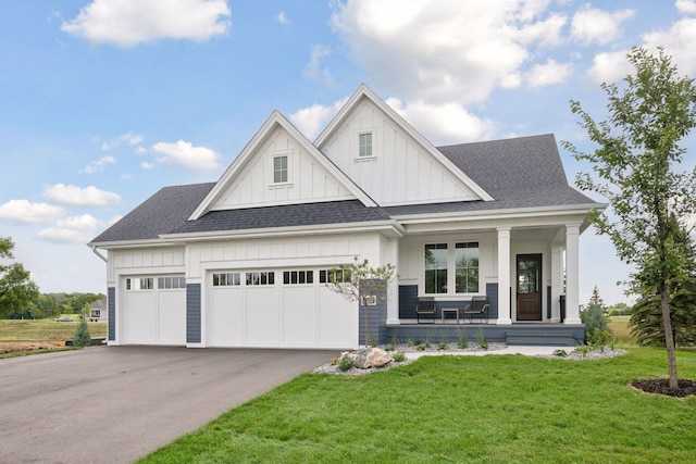 view of front of house with a garage, a porch, and a front yard