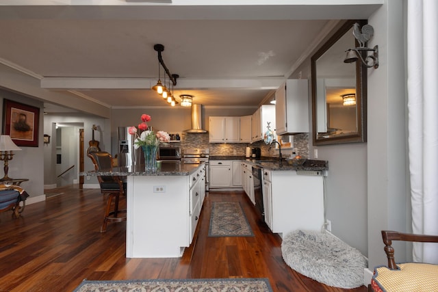 kitchen featuring sink, wall chimney exhaust hood, decorative backsplash, a kitchen island, and white cabinetry