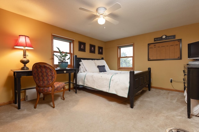 carpeted bedroom featuring multiple windows and ceiling fan