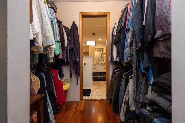 walk in closet with dark hardwood / wood-style floors