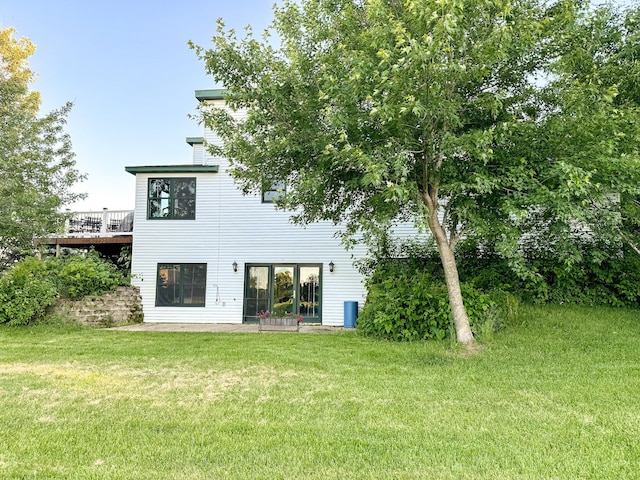 back of property featuring a yard and a deck