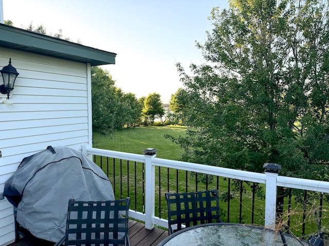 wooden deck with a yard and area for grilling