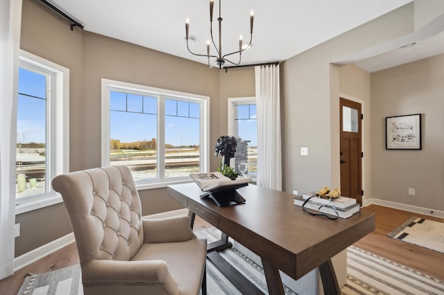 office space with a notable chandelier and light hardwood / wood-style floors