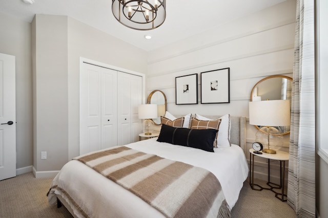 bedroom featuring light carpet, a closet, and a notable chandelier