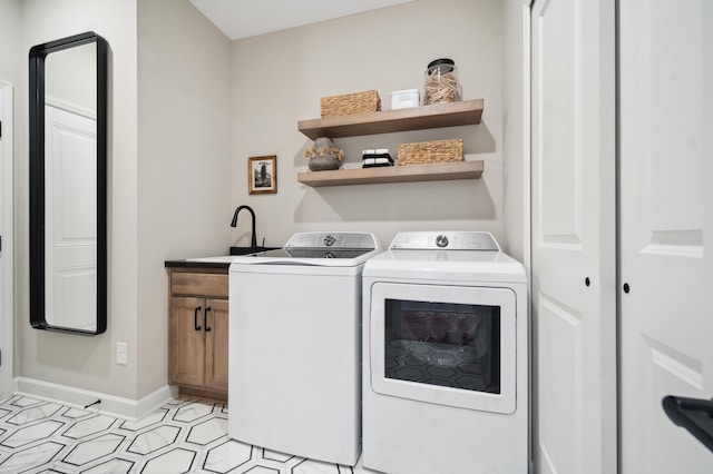 clothes washing area featuring washer and dryer, cabinets, sink, and light tile flooring