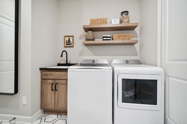 washroom featuring cabinets, light tile floors, sink, and washing machine and clothes dryer