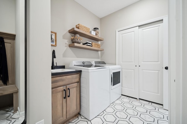 washroom featuring light tile floors, cabinets, separate washer and dryer, and sink