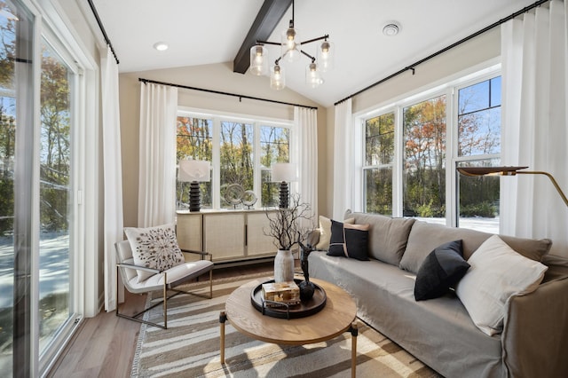 sunroom / solarium with lofted ceiling with beams and an inviting chandelier