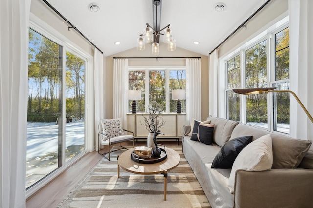 sunroom / solarium featuring lofted ceiling and an inviting chandelier