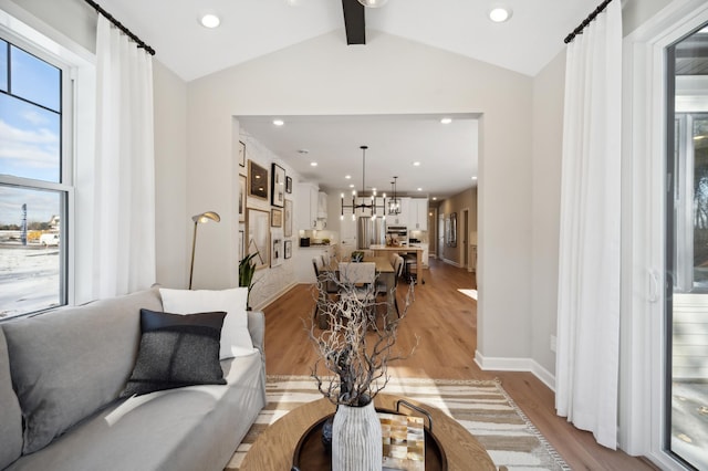 living room featuring lofted ceiling with beams and light wood-type flooring