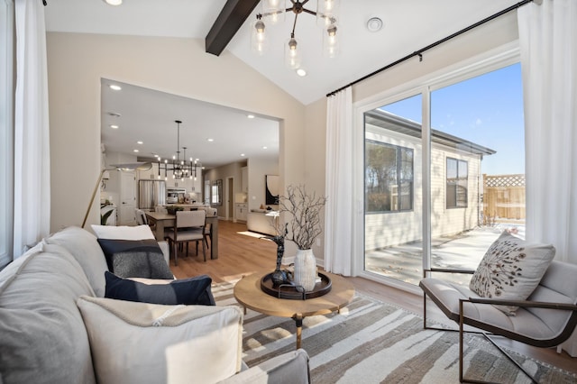 living room with a chandelier, vaulted ceiling with beams, and light wood-type flooring