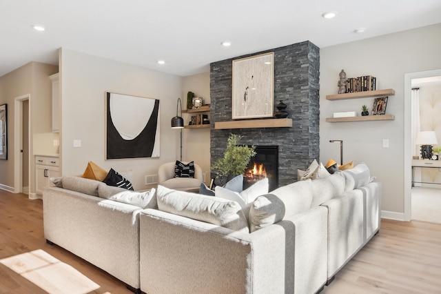 living room with a fireplace and light wood-type flooring