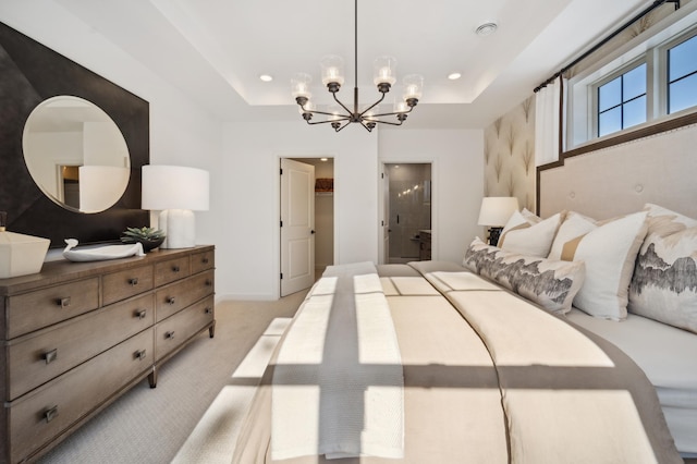 carpeted bedroom featuring a spacious closet, a chandelier, ensuite bath, and a tray ceiling