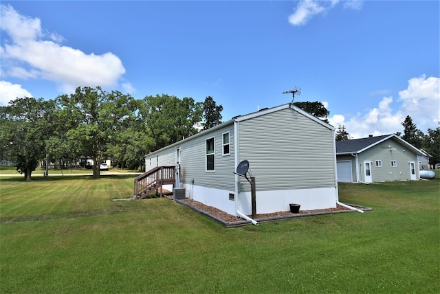 view of side of property featuring a lawn and central AC unit