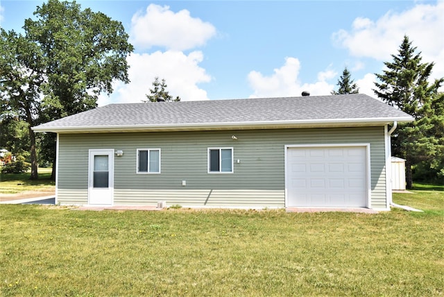 back of house with a yard and a garage