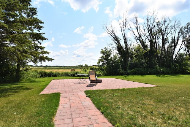 view of property's community featuring a patio area and a lawn