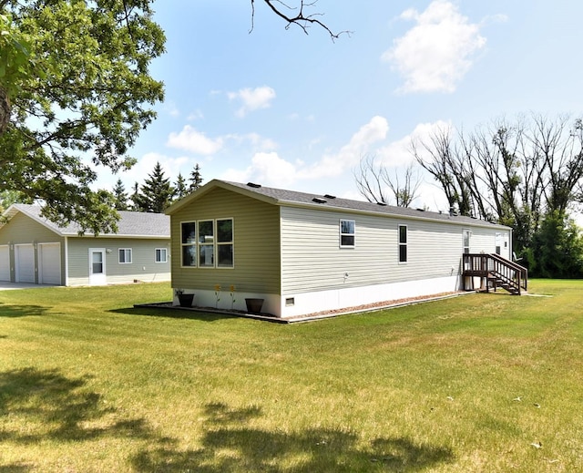 back of house featuring a garage and a yard