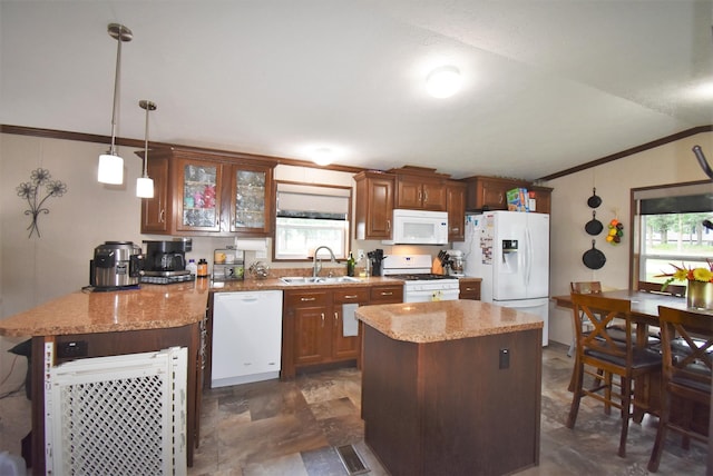 kitchen with decorative light fixtures, sink, white appliances, and a healthy amount of sunlight