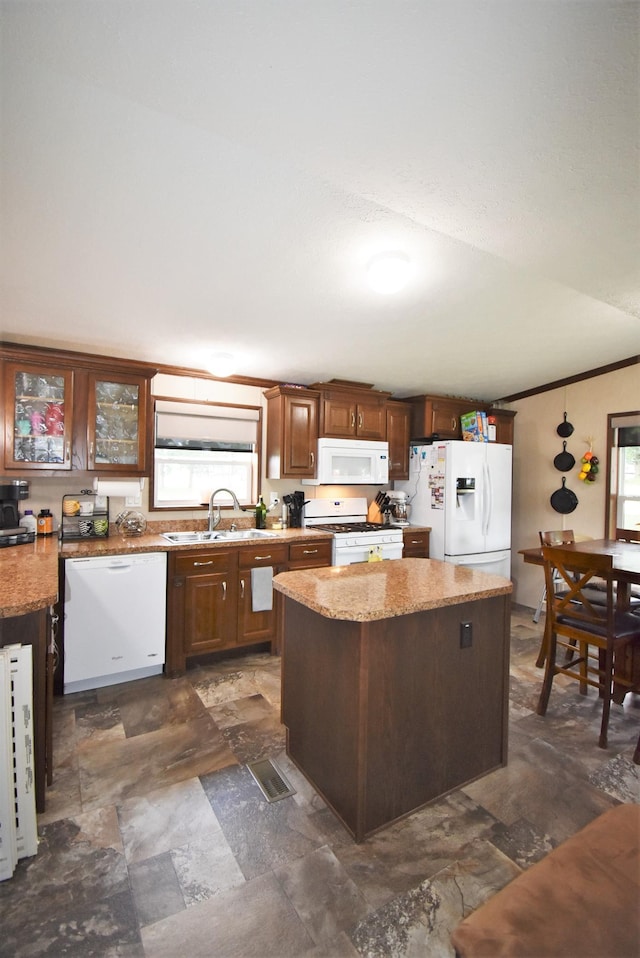 kitchen featuring a center island, sink, white appliances, dark tile flooring, and light stone countertops