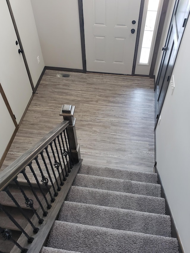 stairs with dark hardwood / wood-style floors