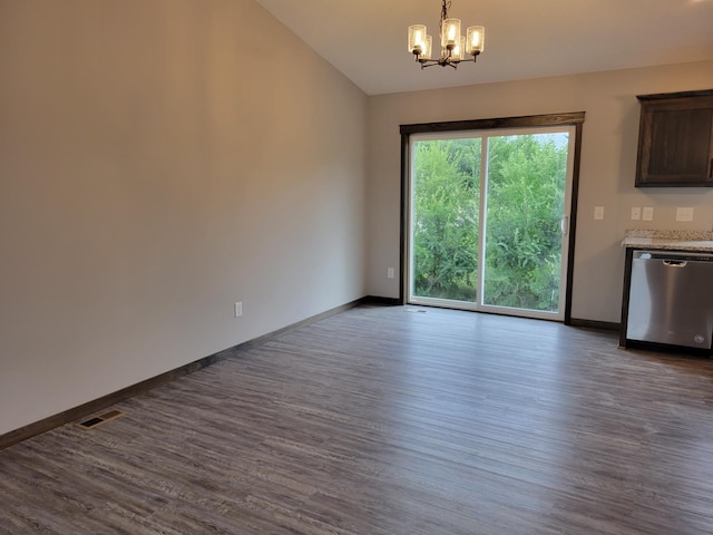 unfurnished dining area featuring vaulted ceiling, dark hardwood / wood-style flooring, and an inviting chandelier