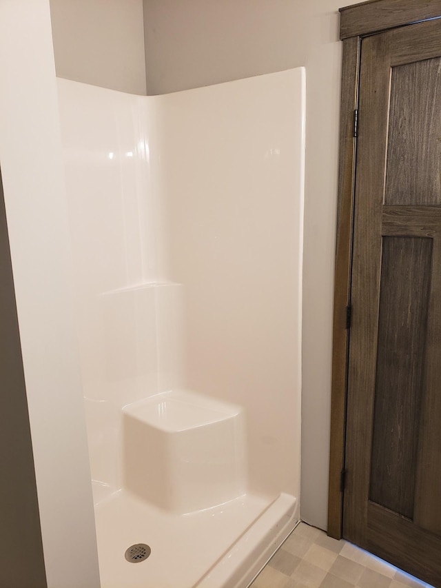 bathroom featuring walk in shower and tile floors