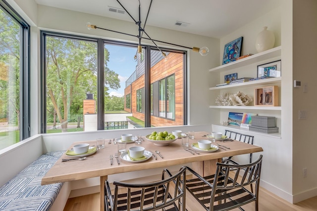 dining room featuring breakfast area, light hardwood / wood-style floors, and built in shelves